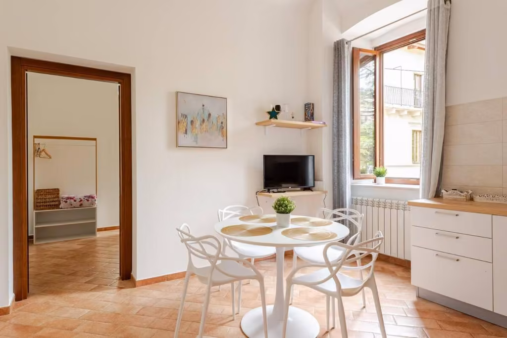 Zona pranzo con tavolo e sedie della dimora in Via San Crisante